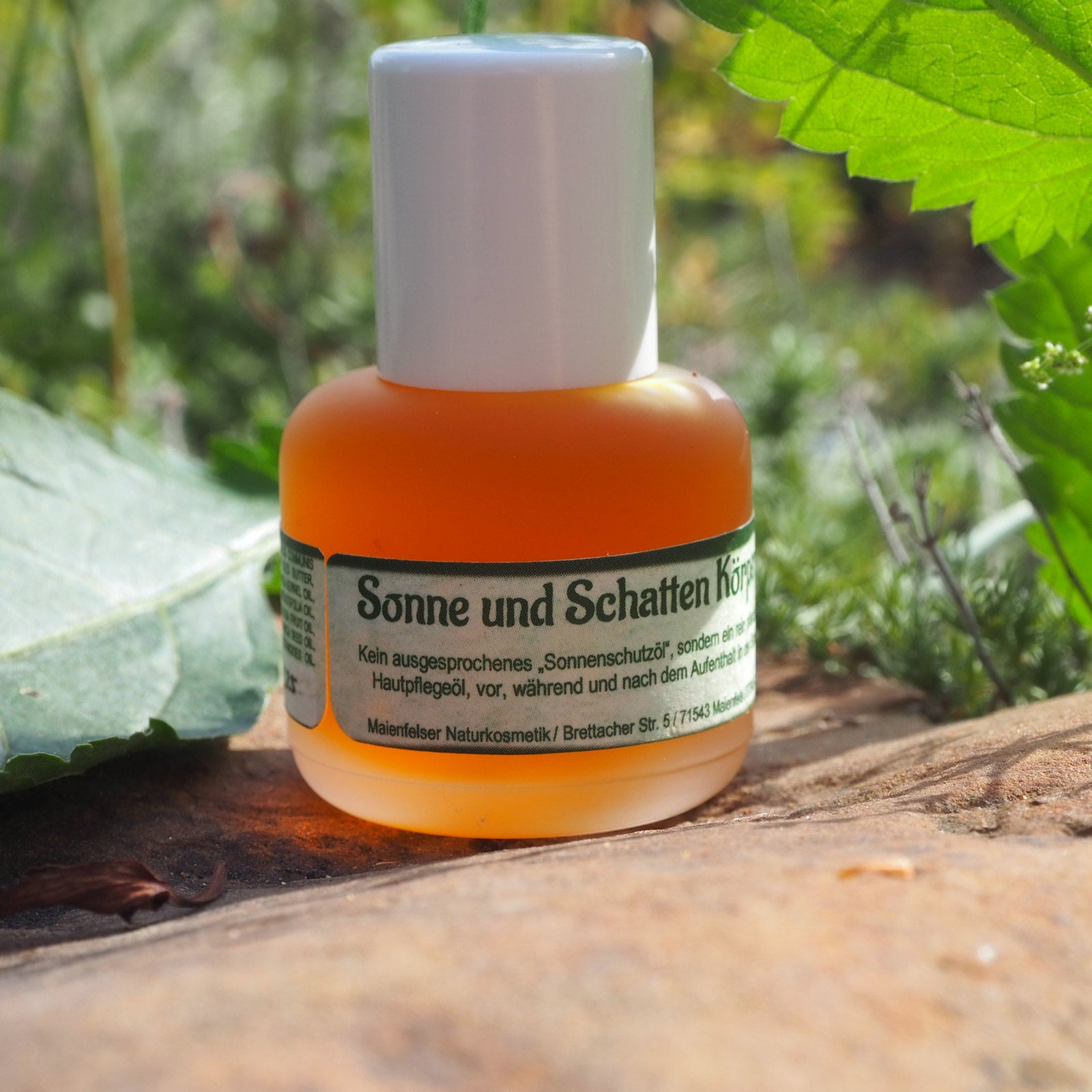 Sonne und Schatten Körperöl 15m auf einem Stein stehend mit grünen Blättern